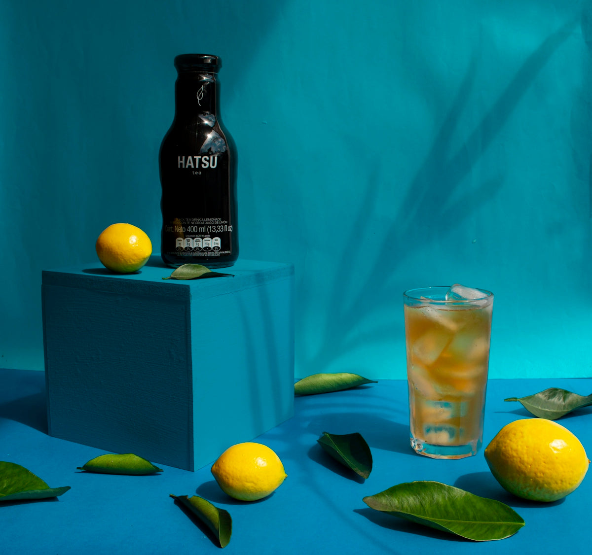 A bottle of hatsu drink with lemons and ice tea.